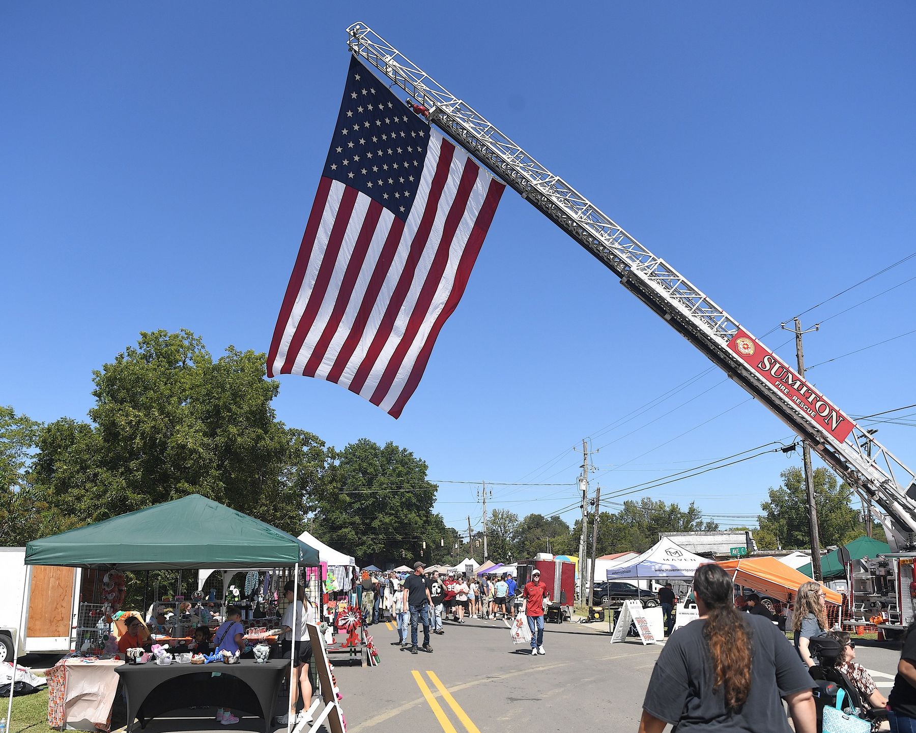 An American flag hung from a fire truck ladder over the festival